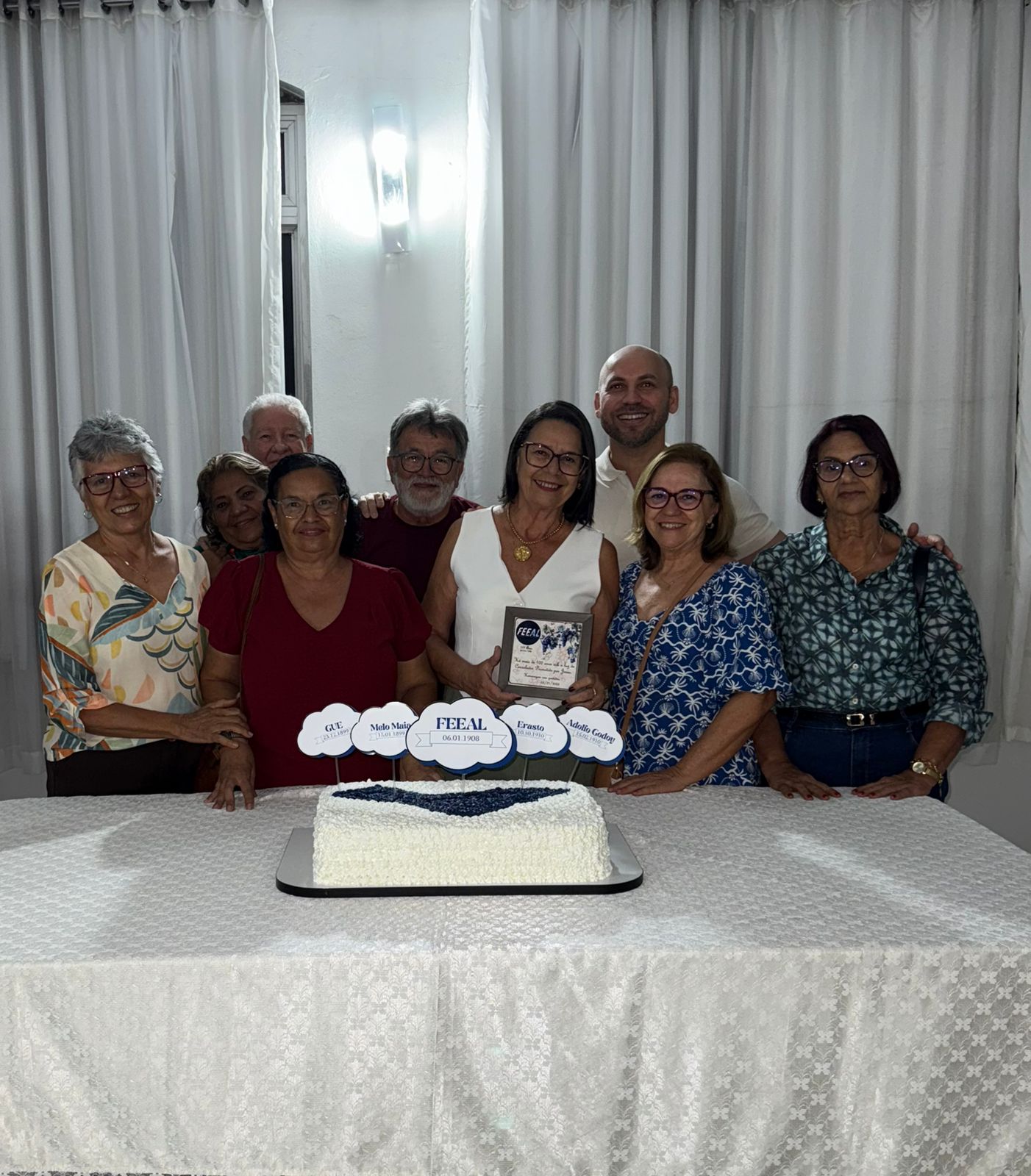 Membros do Colegiado Diretor da FEEAL reunidos ao redor de um bolo decorado em celebração aos 117 anos de fundação.